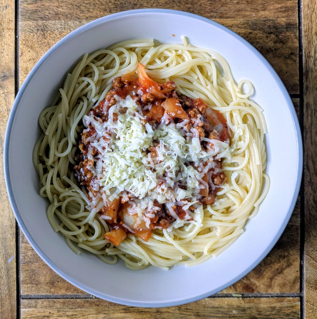 Cheap meals on a budget uk spaghetti bolognese topped with grated cheese