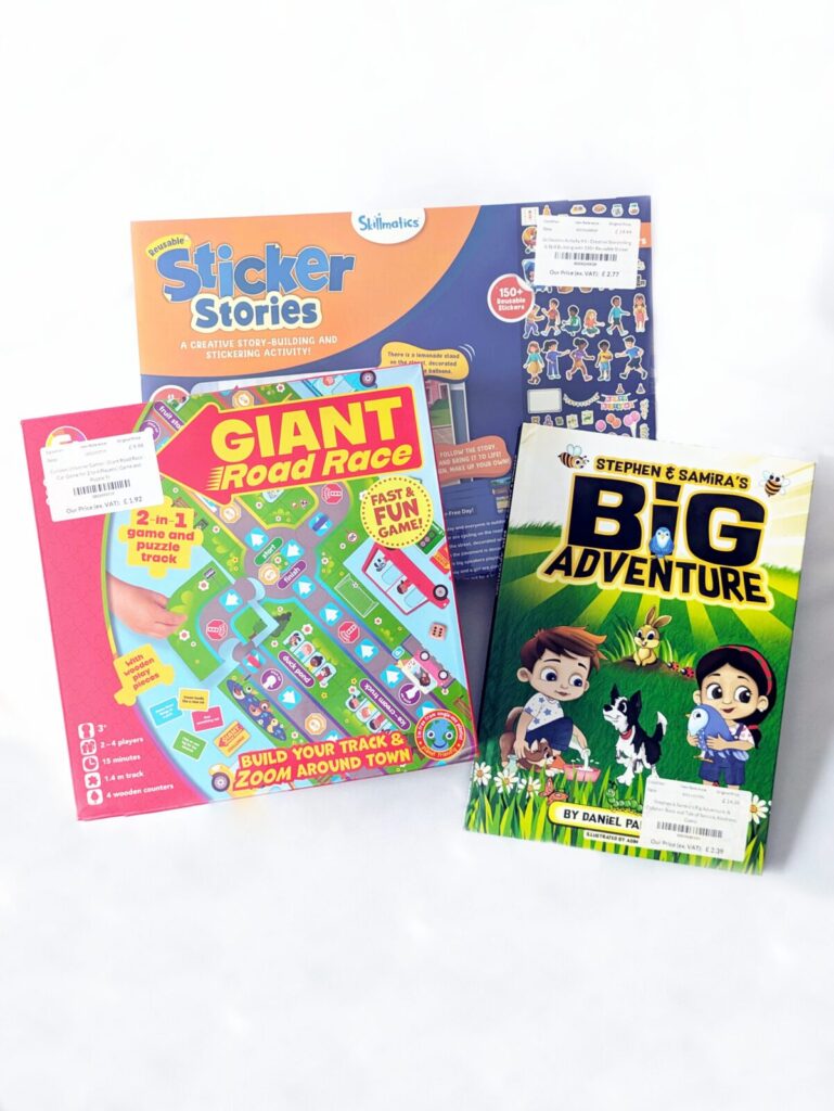 Cheap liquidation toys bought from a UK trade outlet warehouse showing sticker books, storybooks, and a giant road race game.